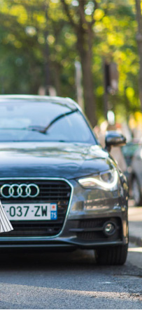 Modelo usando Saia Plissado andando na rua e com carro estacionado ao lado.